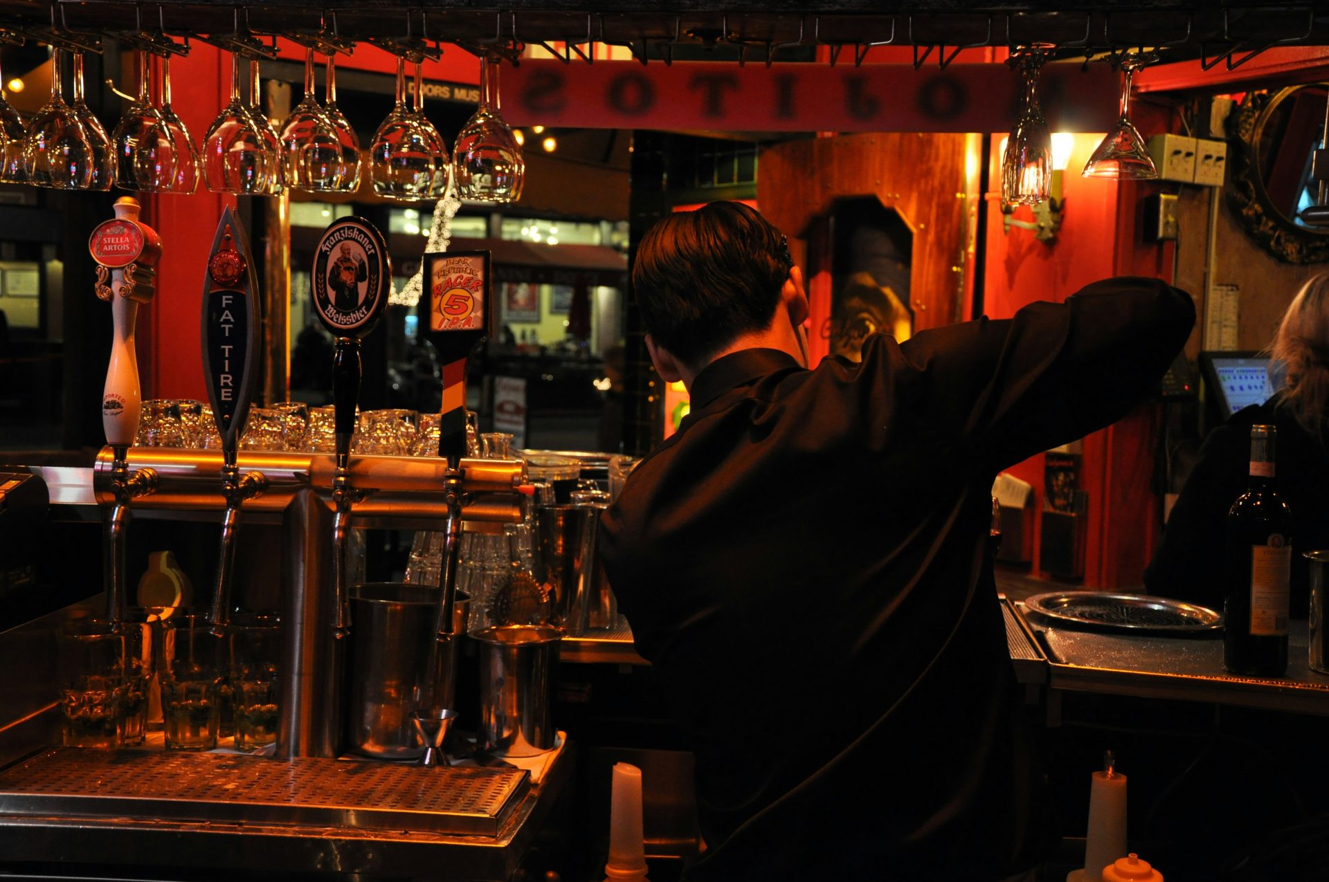 a man standing at a bar pouring a drink